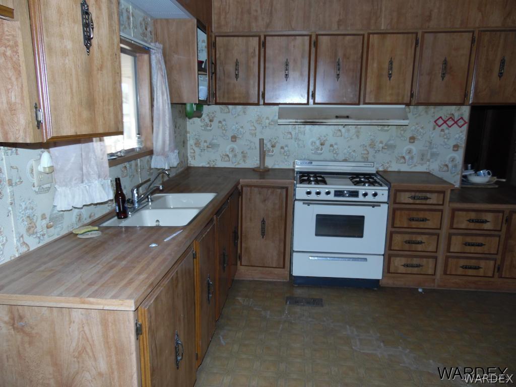 5654 Pasadena Road Fort Mohave, AZ 86426 - Photo 7 of 17 a kitchen with a sink stove and cabinets