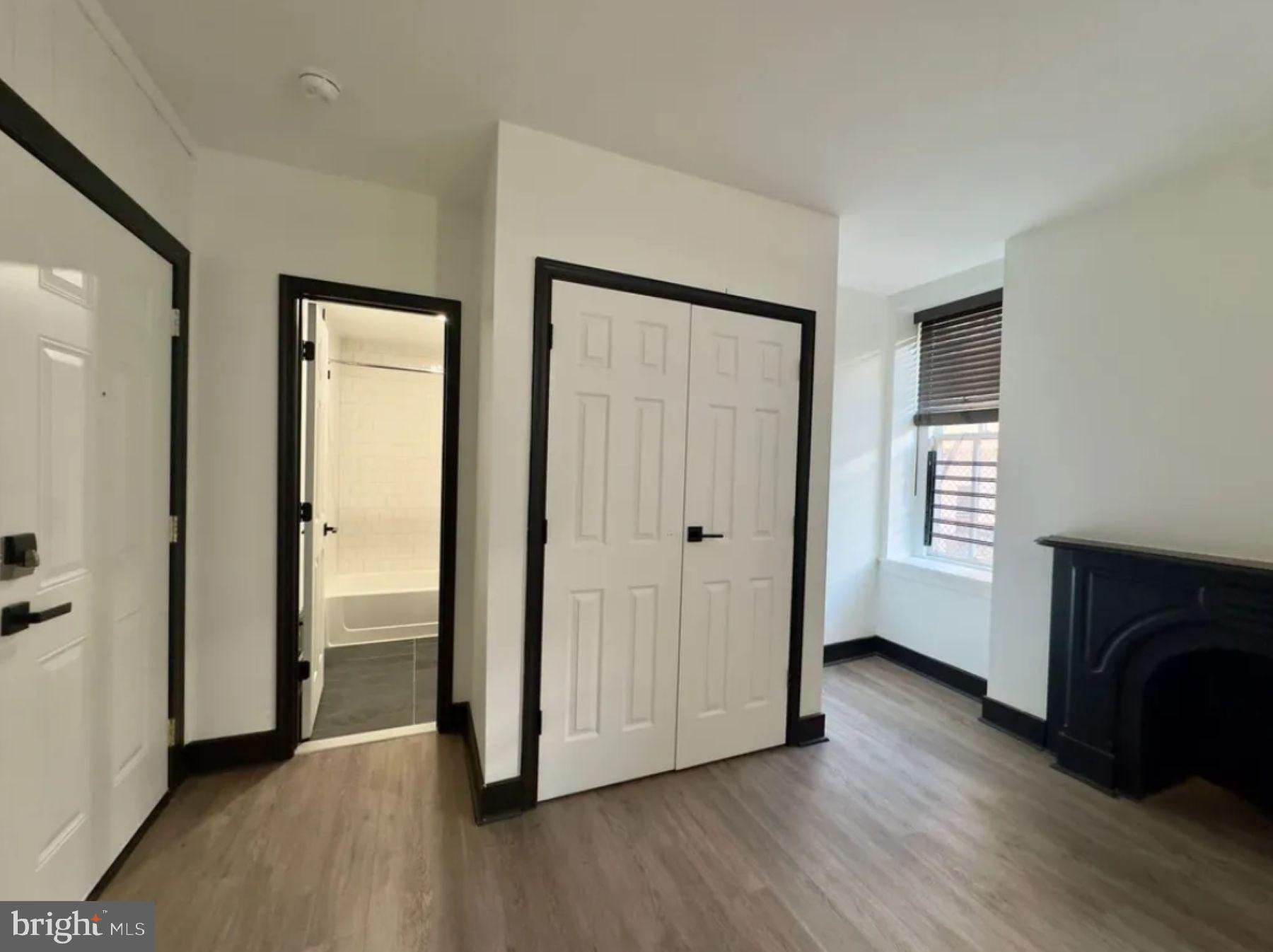 938 North Calvert Street, Unit T Baltimore, MD 21202 - Photo 3 of 6 a view of a livingroom with wooden floor and a fireplace