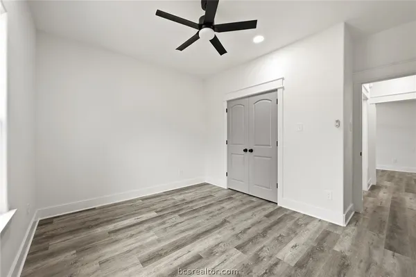an empty room with a window and a ceiling fan