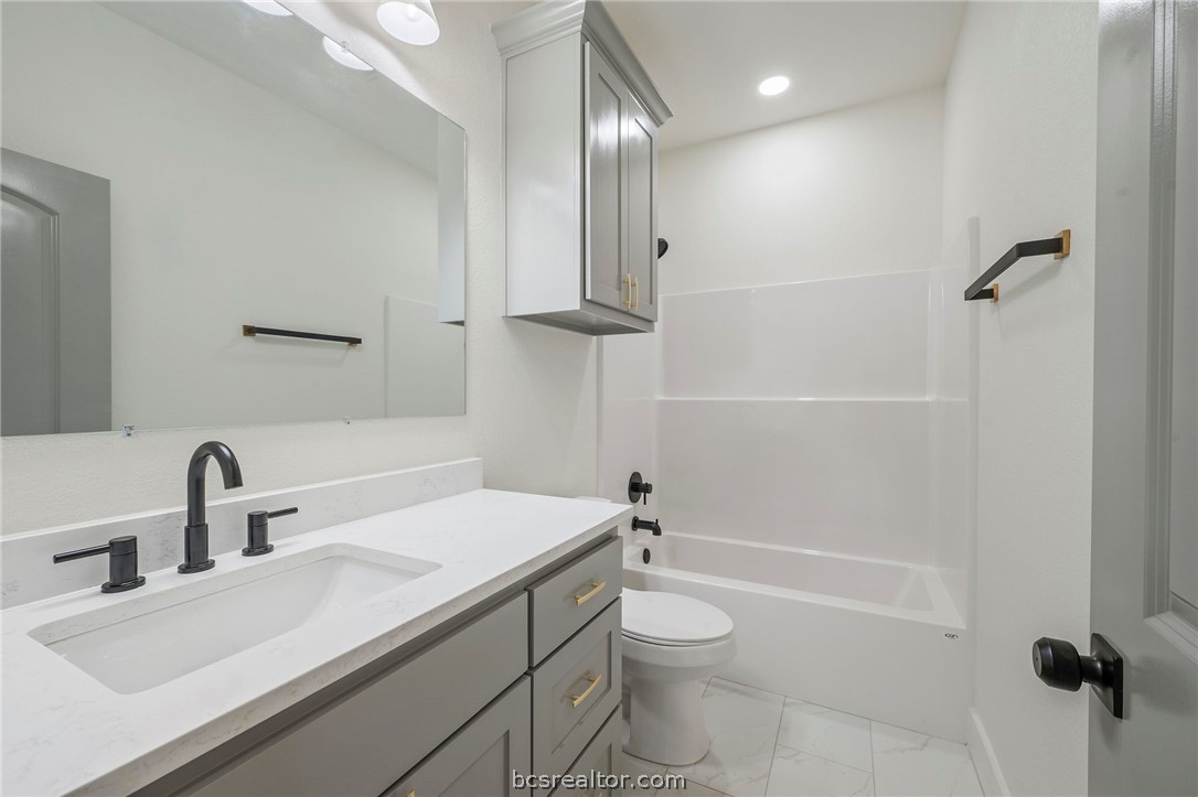 203 Lock Lane Bryan, TX 77803 - Photo 15 of 22 a bathroom with a sink a toilet and shower
