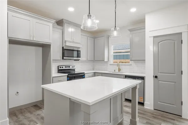 a kitchen with a sink a microwave a stove and refrigerator