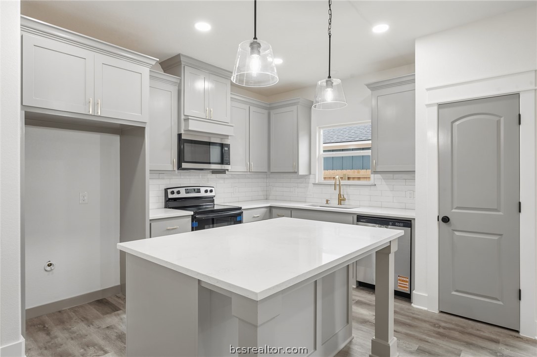 203 Lock Lane Bryan, TX 77803 - Photo 2 of 22 a kitchen with a sink a microwave a stove and refrigerator