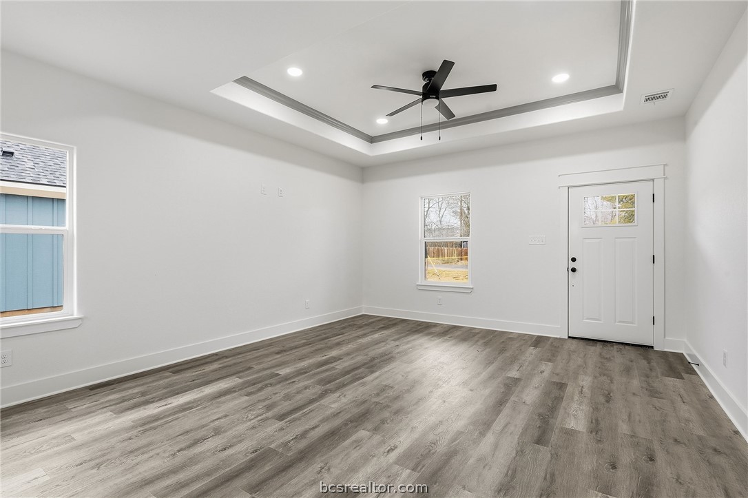 203 Lock Lane Bryan, TX 77803 - Photo 6 of 22 an empty room with wooden floor ceiling fan and windows