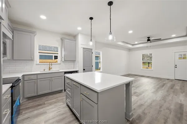 a kitchen with a sink stove and wooden floor