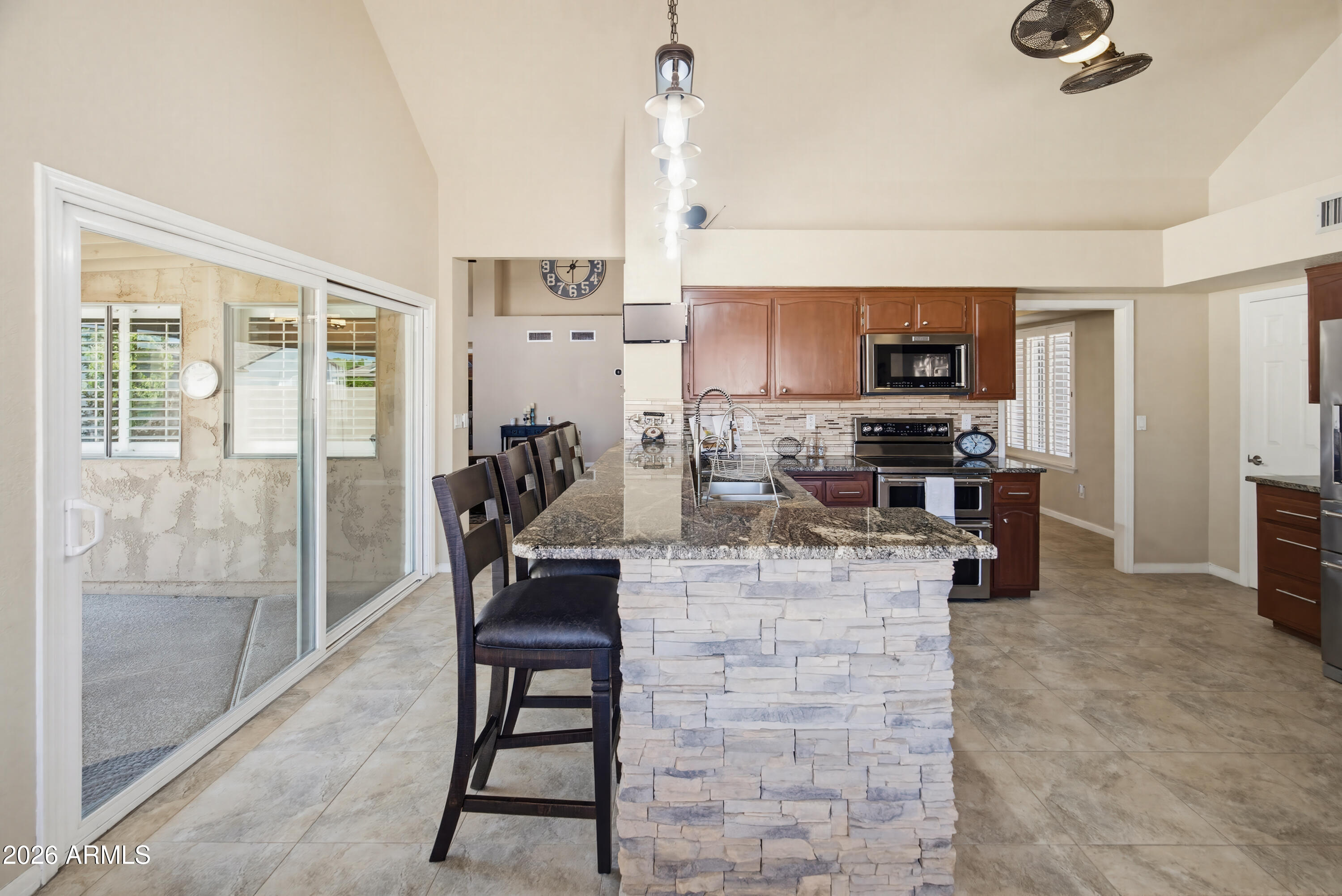 841 North Gentry Mesa, AZ 85213 - Photo 12 of 74 a kitchen with stainless steel appliances kitchen island granite countertop a refrigerator and a stove top oven