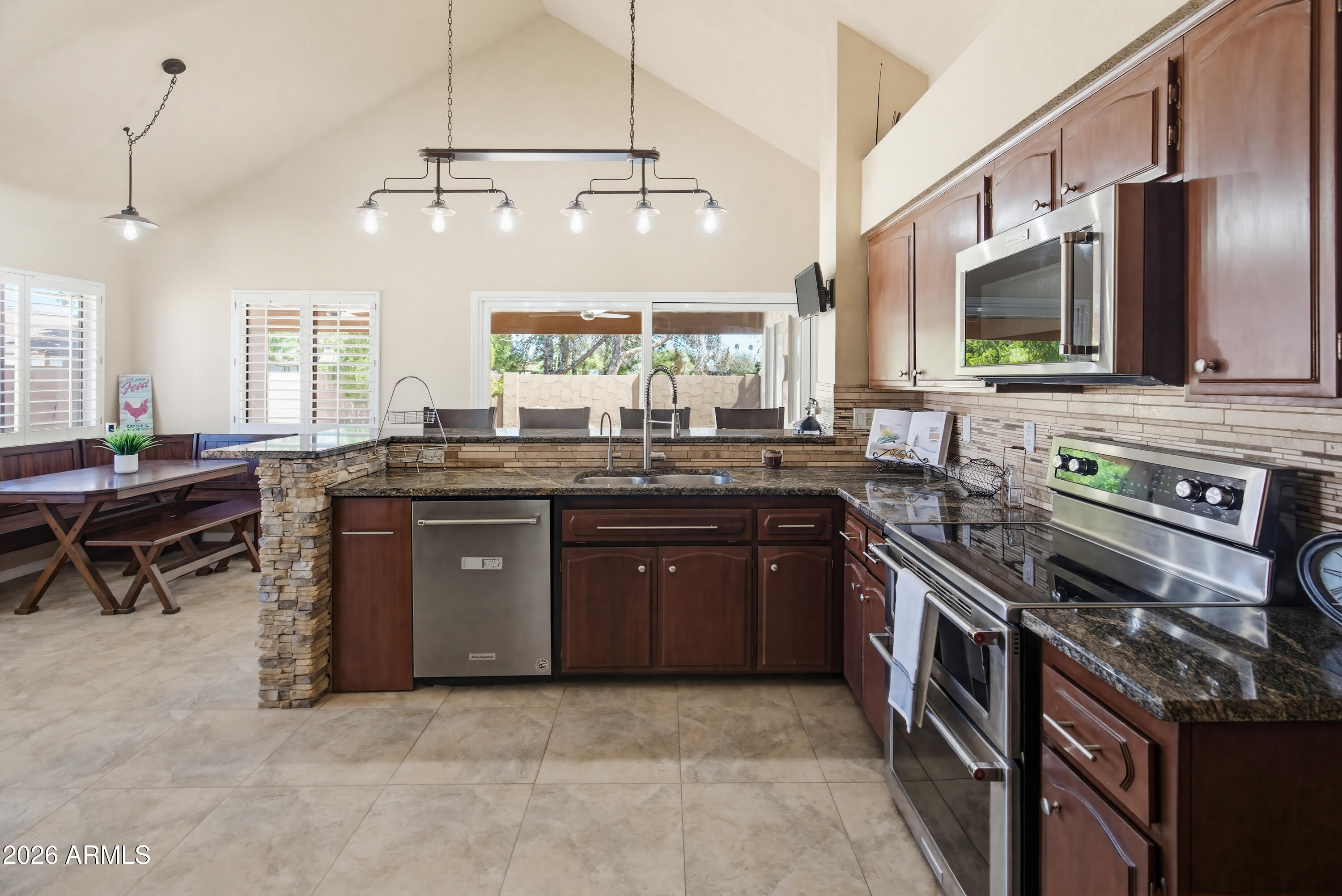 841 North Gentry Mesa, AZ 85213 - Photo 15 of 74 a kitchen with stainless steel appliances granite countertop a stove a sink and a microwave