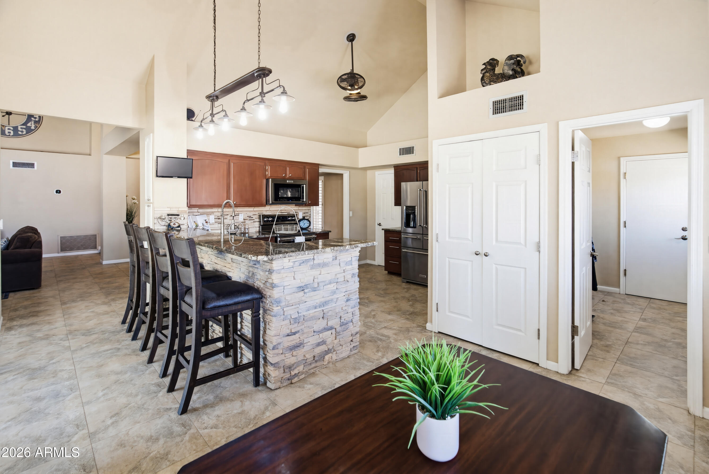 841 North Gentry Mesa, AZ 85213 - Photo 17 of 74 a kitchen with stainless steel appliances kitchen island granite countertop a refrigerator a stove a microwave oven a dining table and chairs with wooden floor