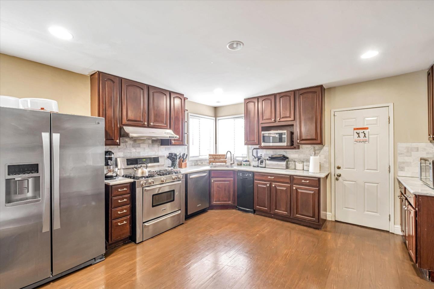 8245 Golf Links Road Oakland, CA 94605 - Photo 11 of 41 a kitchen with stainless steel appliances granite countertop a stove top oven a refrigerator a sink and dishwasher