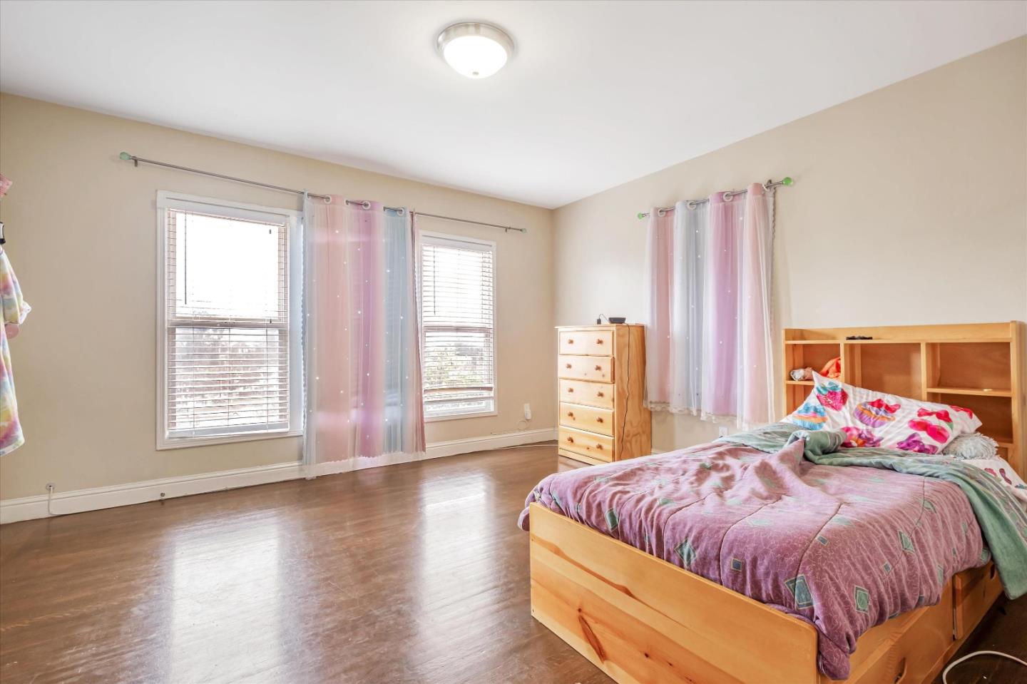 8245 Golf Links Road Oakland, CA 94605 - Photo 23 of 41 a spacious bedroom with a bed and wooden floor