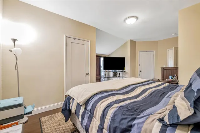 a bedroom with a bed and a flat screen tv