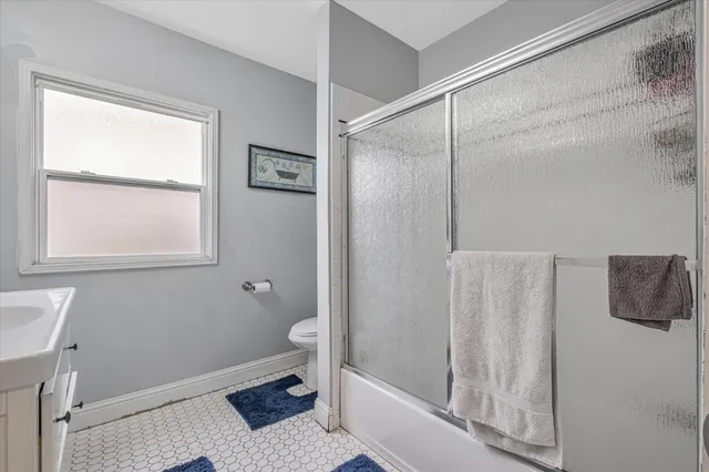 a bathroom with a granite countertop sink a toilet and shower