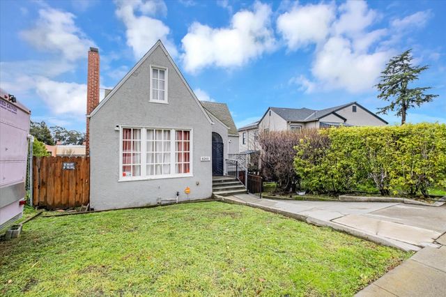 a view of a house with a yard and flower plants