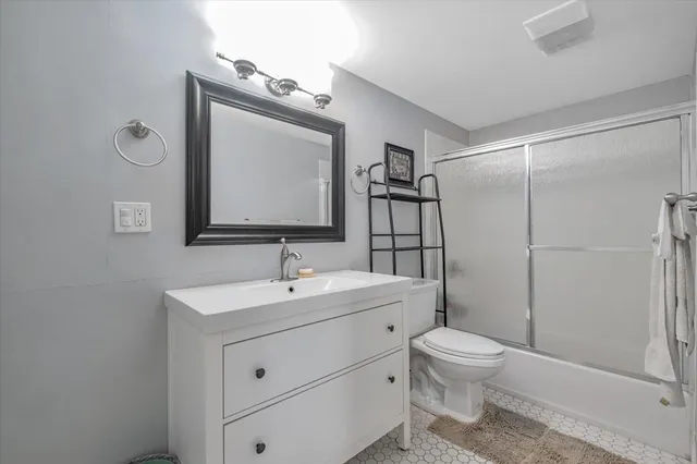 a bathroom with a toilet sink shower and mirror