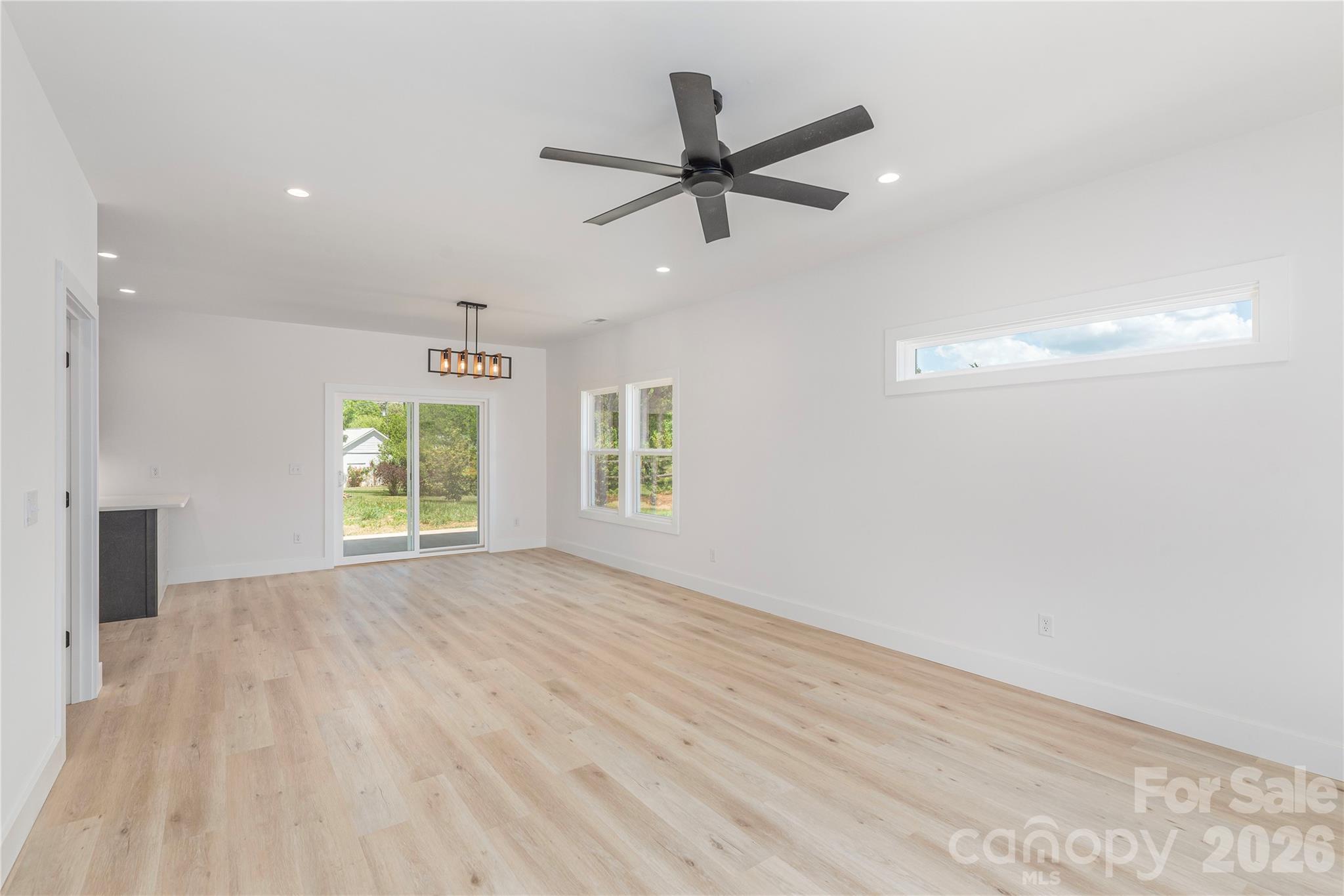 32 Oak Hill Road Candler, NC 28715 - Photo 7 of 29 an empty room with windows and fan