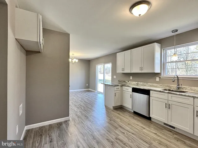 a kitchen with a sink cabinets stainless steel appliances and window