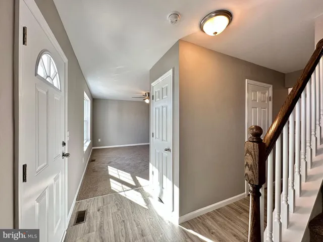 a view of a hallway with wooden floor and staircase