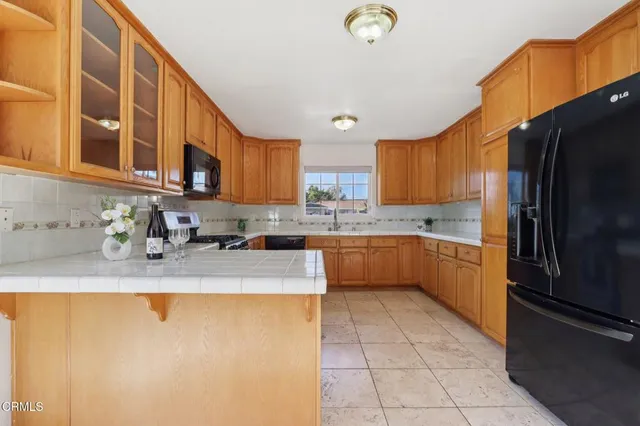 a kitchen with stainless steel appliances granite countertop a sink refrigerator and cabinets