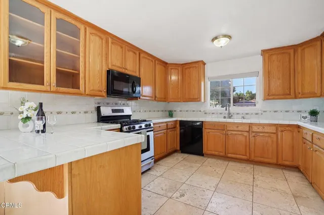 a kitchen with stainless steel appliances granite countertop a stove a sink a microwave and a refrigerator