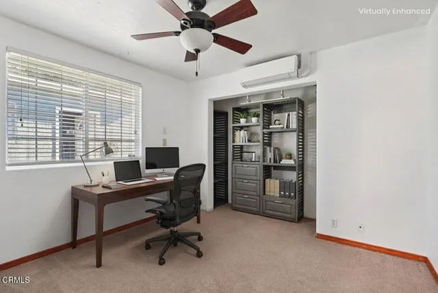 a view of a workspace with furniture and a window