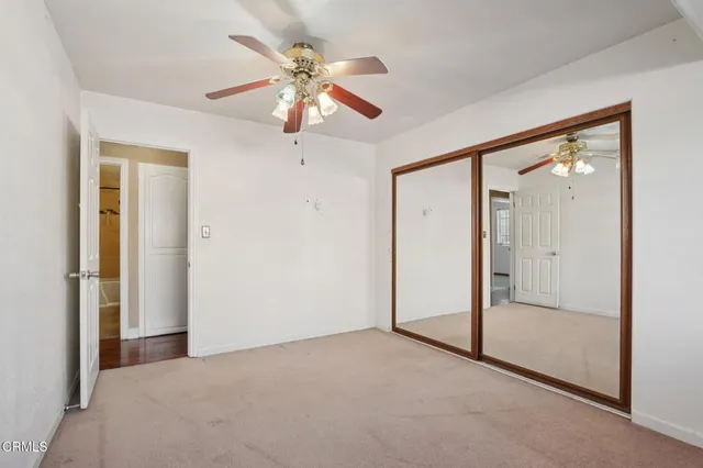 an empty room with fan and entrance