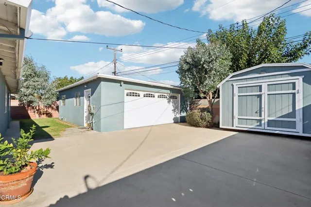 a view of a house with a garage and outdoor kitchen