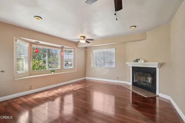 wooden floor fireplace and windows in an empty room