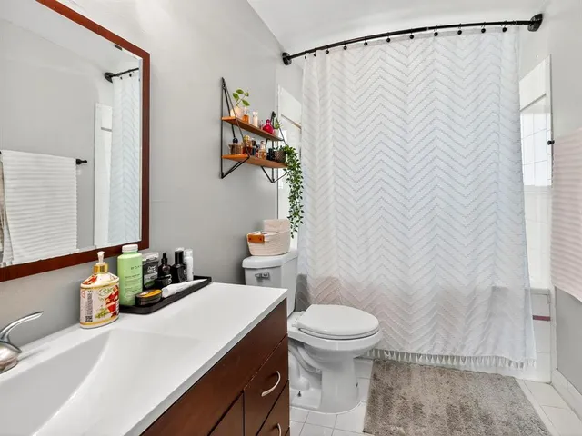 a bathroom with a sink a toilet and shower curtain