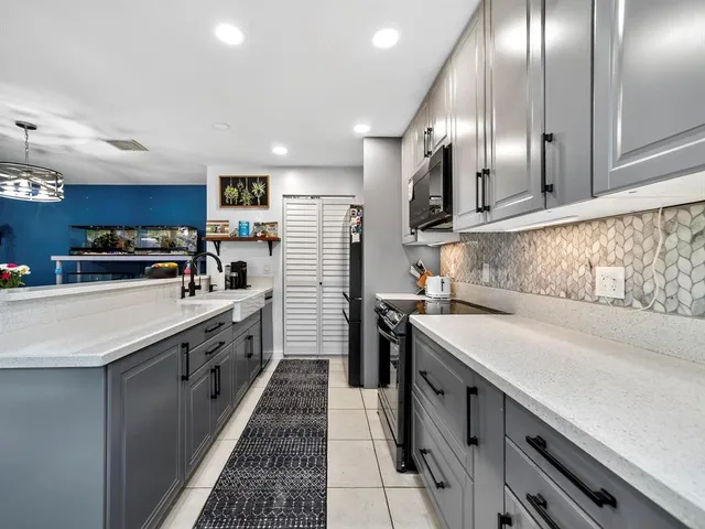 a kitchen with stainless steel appliances granite countertop a sink a stove and cabinets