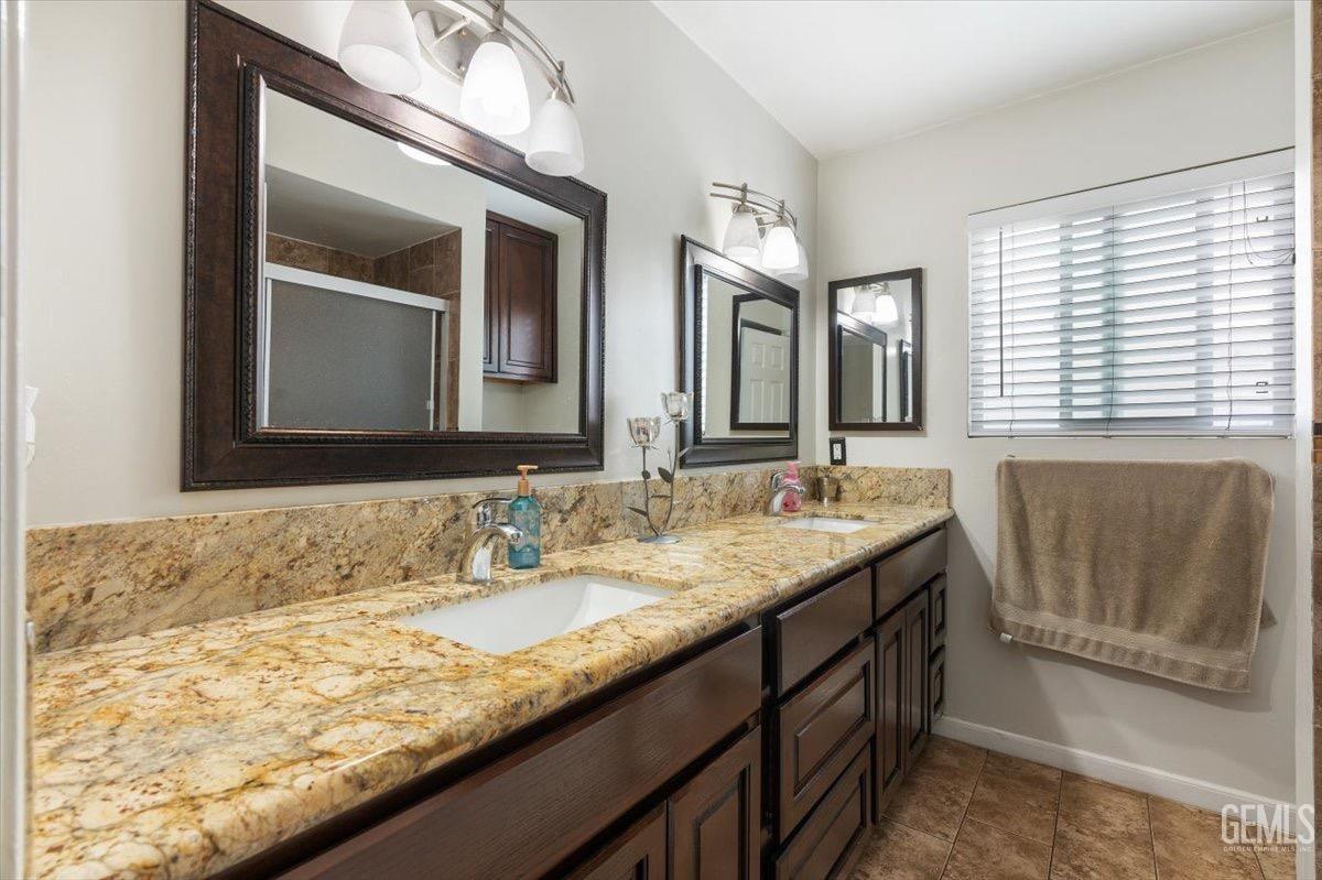 Undisclosed Address Bakersfield, CA 93309 - Photo 11 of 30 a bathroom with a granite countertop sink and a mirror