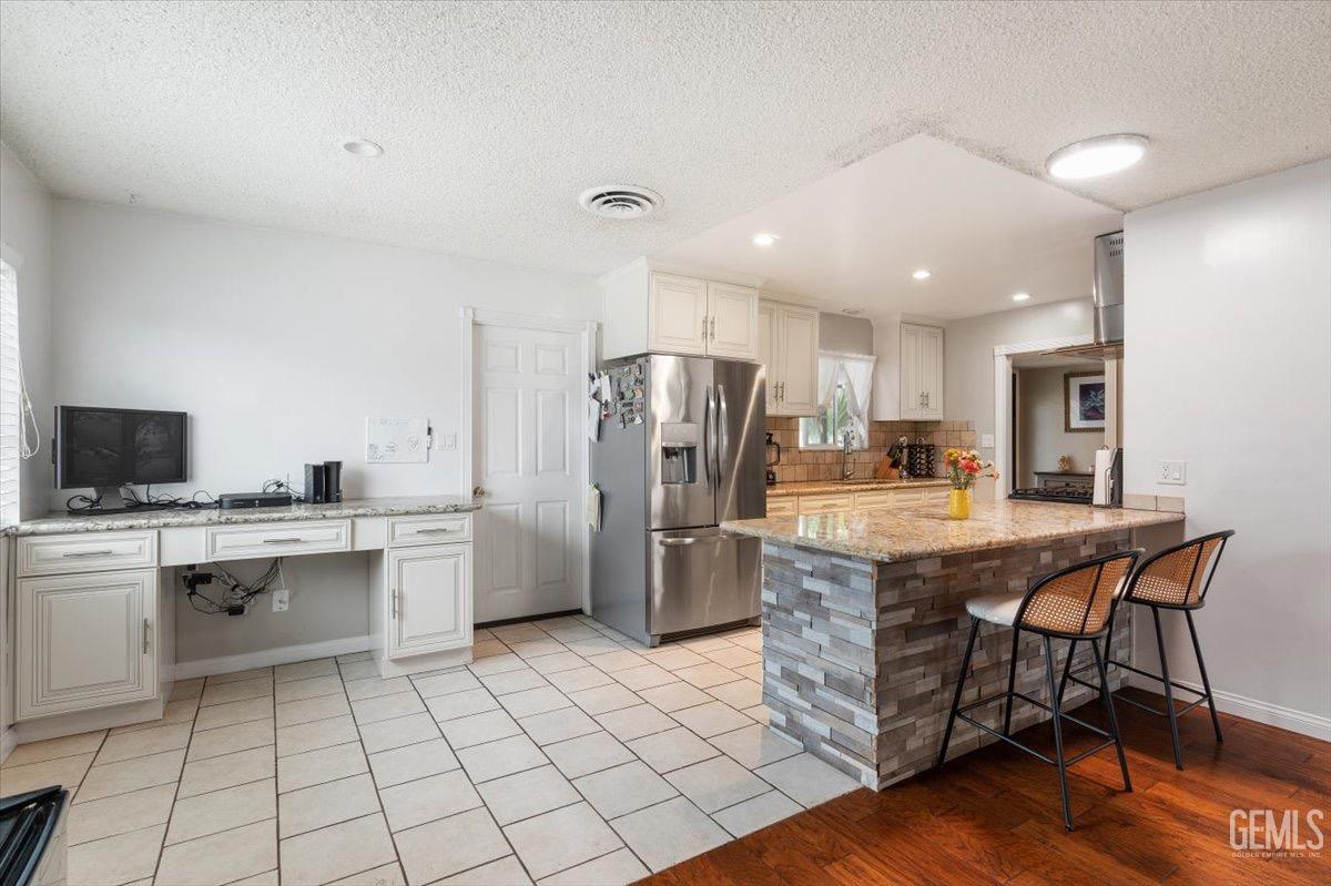 Undisclosed Address Bakersfield, CA 93309 - Photo 18 of 30 a kitchen with stainless steel appliances a sink a stove a refrigerator cabinets and a dining table