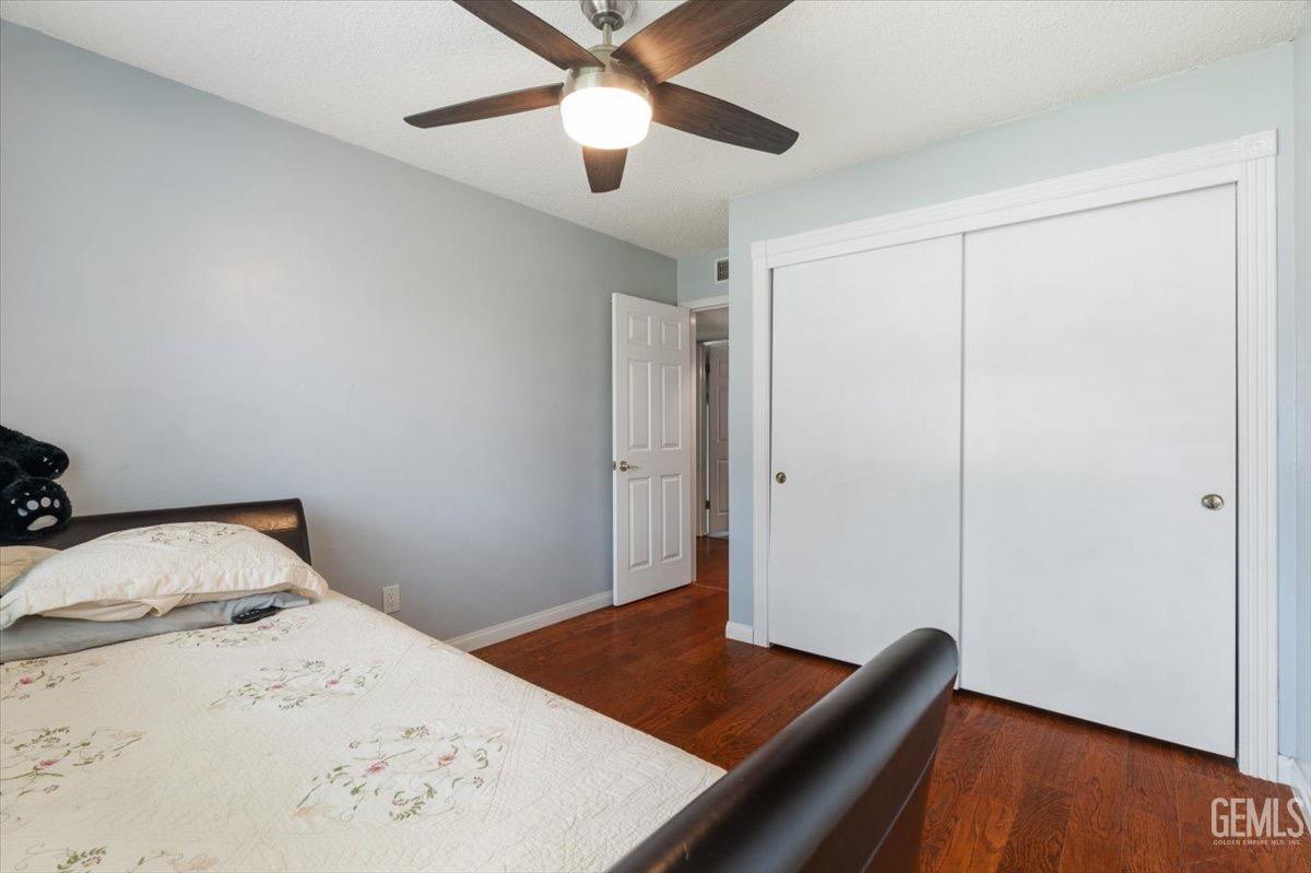 Undisclosed Address Bakersfield, CA 93309 - Photo 5 of 30 a bedroom with a bed and a dresser with wooden floor
