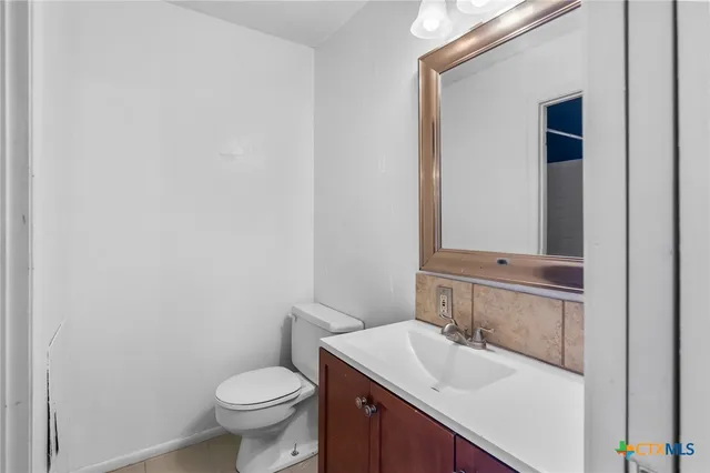 a bathroom with a granite countertop toilet and sink