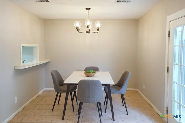 a view of a dining room with furniture and chandelier
