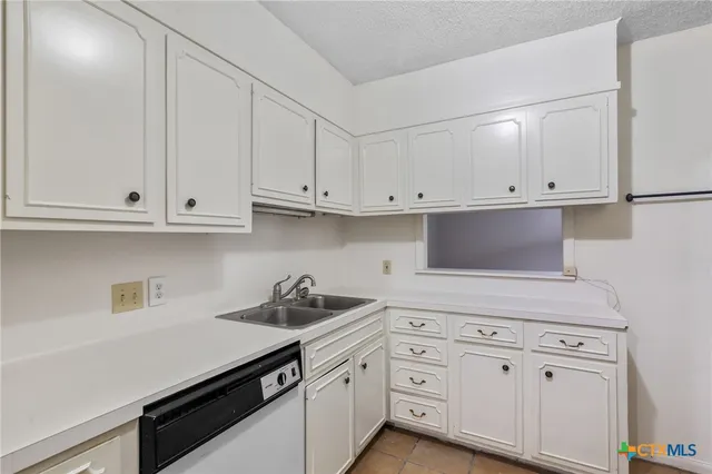 a kitchen with white cabinets and white appliances