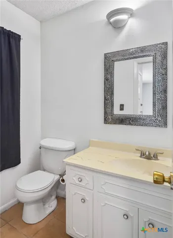 a bathroom with a toilet a sink and mirror