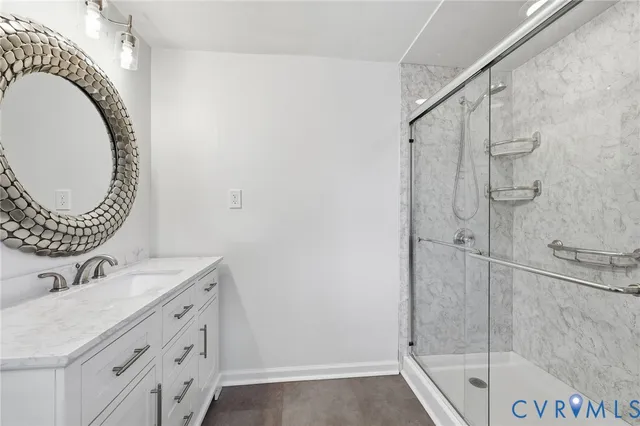 a bathroom with a granite countertop sink a mirror and a shower