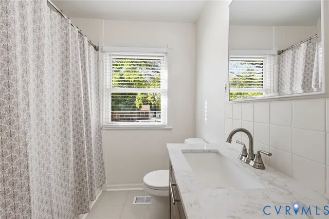 a bathroom with a sink a toilet and a window