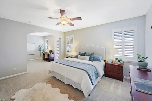 a bedroom with a bed chandelier and a window