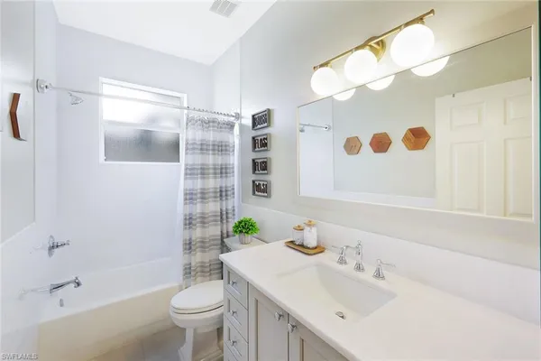 a bathroom with a sink and mirror with toilet