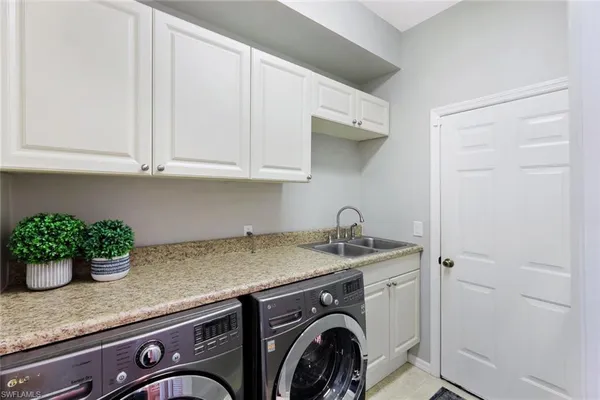 a utility room with granite countertop a sink