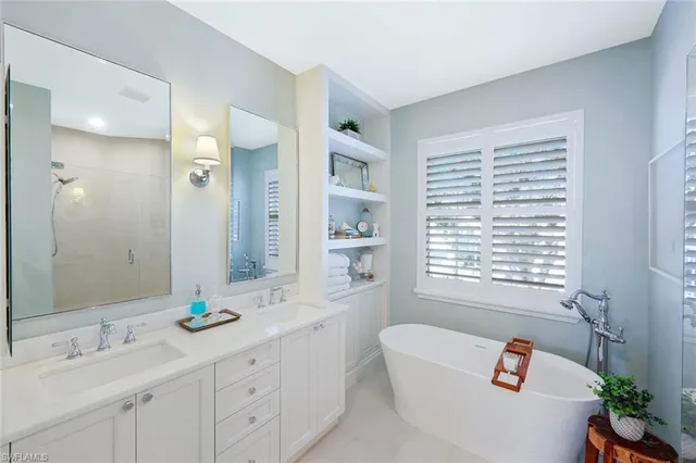 a bathroom with a double vanity sink window and bathtub