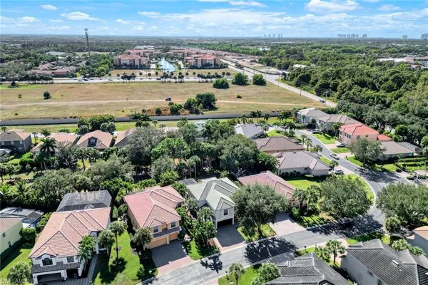 an aerial view of a city with lots of residential buildings ocean and mountain view in back