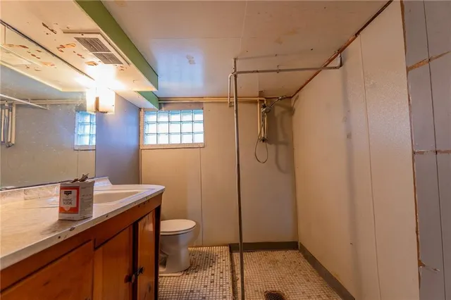a bathroom with a sink a toilet and shower