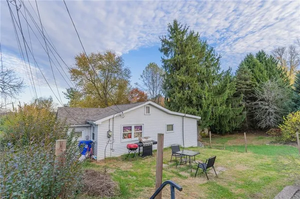a view of backyard with table and chairs and potted plants