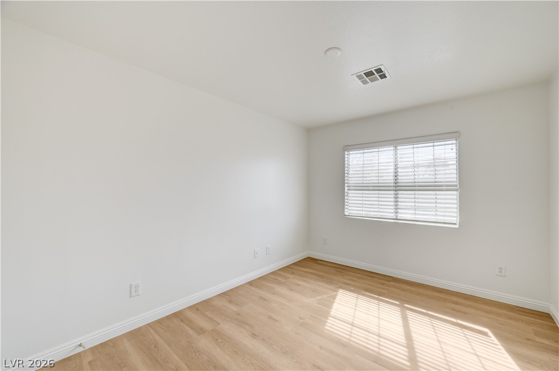 8918 Houston Ridge Avenue Las Vegas, NV 89178 - Photo 27 of 35 A well-lit room featuring durable wood flooring and ample natural illumination.
