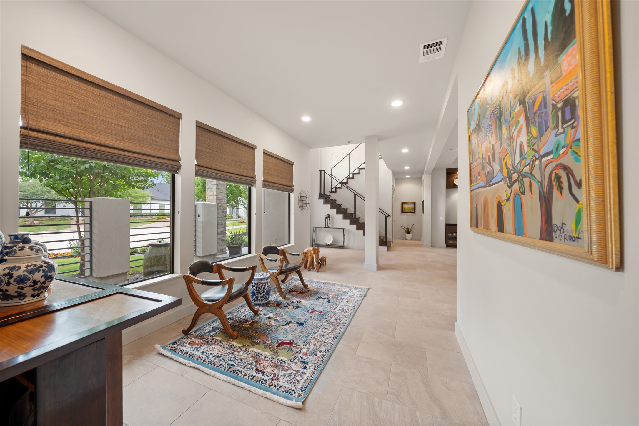 24902 Delaney Knoll Spring, TX 77389 - Photo 3 of 49 Luminous gallery hall featuring expansive windows and a sleek staircase, creating a sophisticated transition toward the primary suite.