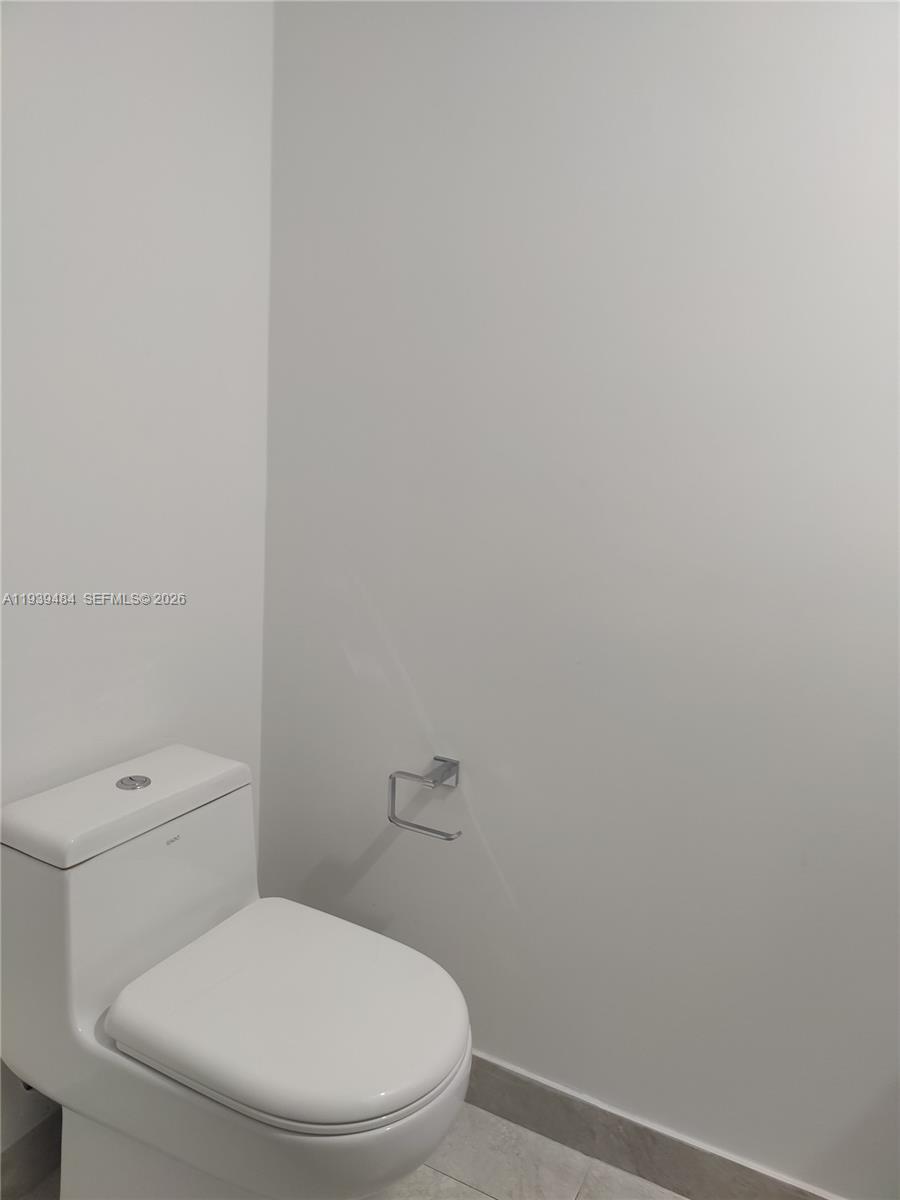 488 Northeast 18th Street, Unit 403 Miami, FL 33132 - Photo 12 of 13 a white toilet sitting next to a white wall