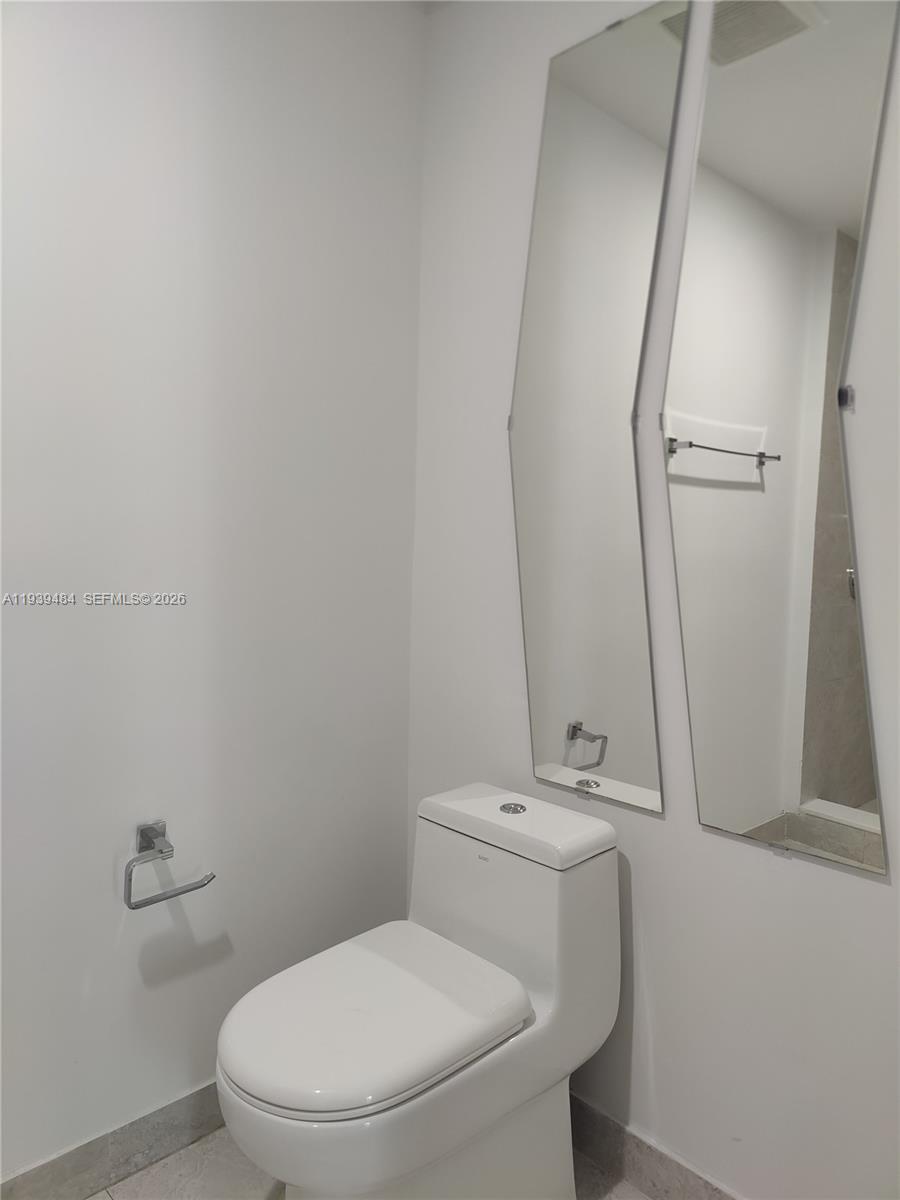 488 Northeast 18th Street, Unit 403 Miami, FL 33132 - Photo 10 of 13 a white toilet sitting next to a bathroom sink