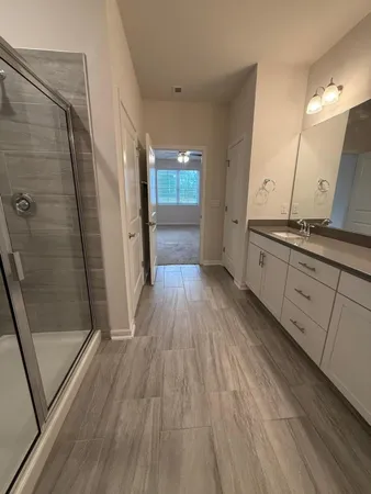 a bathroom with a sink a toilet a mirror and shower