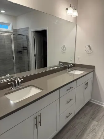 a bathroom with double sink and a mirror